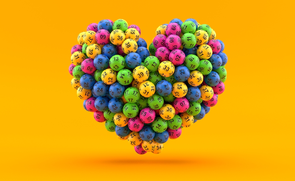 Lottery balls in heart shape isolated on yellow background.